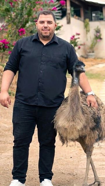 Emu faz pose para foto ao lado de criador Rafael Augusto dos Santos Souza da Oinque